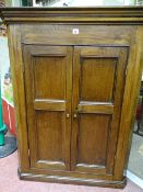 AN OAK TWO DOOR PANEL FRONT WALL HANGING CORNER CUPBOARD with shaped interior shelves, 111 cms high,