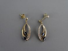 A PAIR OF NINE CARAT GOLD OVAL LEAF SHAPED EARRINGS with an outer band of czs and two oval cut