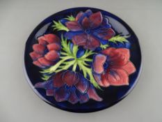 A MOORCROFT 'ANEMONE' 25.5 cms DIAMETER PLATE on a cobalt ground, painted and impressed factory