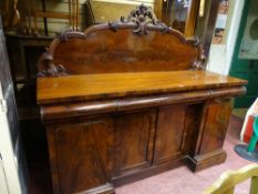 A VICTORIAN DARK MAHOGANY SIDEBOARD having a tall railback with scrolled centre finial and with an