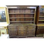 A MID 19th CENTURY OAK WELSH DRESSER having a three shelf rack with turned end pillars and