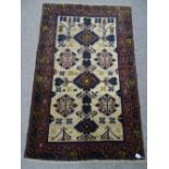 AN OLD BALUCHI CARPET RUNNER having cream ground central panel with traditional motifs and double