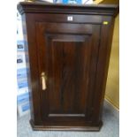 A VINTAGE OAK WALL HANGING CORNER CUPBOARD with single raised panel door and interior shelves, 96