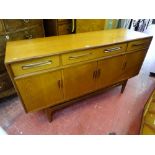 A G-PLAN TEAK LONG SIDEBOARD having three frieze drawers and four cupboard doors, 85 cms high, 152