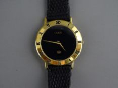 A GENT'S GUCCI 3000M YELLOW METAL CIRCULAR DIAL WRISTWATCH having a black dial with outer bezel