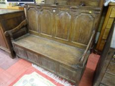 AN EARLY 19th CENTURY BOX SEAT SETTLE with shaped panel back and open arms, peg join construction on