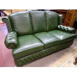 A GOOD GREEN LEATHER EFFECT THREE SEATER COUCH with button upholstered arms, 92 cms high overall,