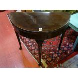 A VINTAGE MAHOGANY HALF MOON FOLDOVER CARD TABLE with baize lined interior, on slender shaped