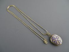 A FOURTEEN CARAT GOLD NECKLACE with blue enamel decorated yellow metal pendant locket, 4.1 grms