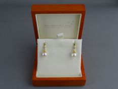 A PAIR OF FOURTEEN CARAT GOLD EARRINGS each having a single Japanese Akoya white pearl and two round