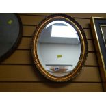 A small gilt framed oval bevelled wall mirror