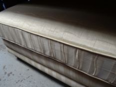 A large foot stool in a striped cream fabric