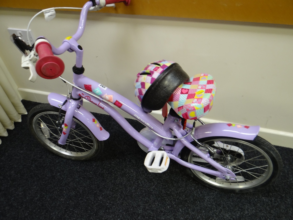 A young girl's Cherry Lane pedal cycle with helmet