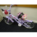 A young girl's Cherry Lane pedal cycle with helmet