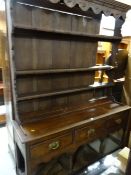 A nineteenth century open rack three-drawer open base Welsh dresser (distressed)