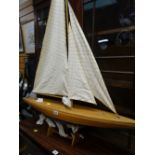 A lightwood pond yacht with canvas sail on stand