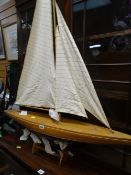 A lightwood pond yacht with canvas sail on stand