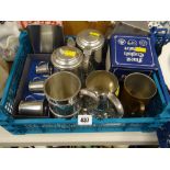 A small crate of pewter items including tankards of various sizes