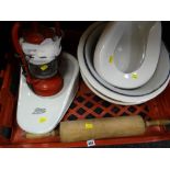 A crate of items including a large wooden rolling pin, two slipper bed pans including one for