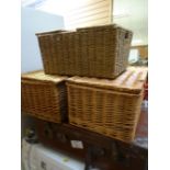 A vintage leather suitcase together with three wicker baskets