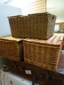 A vintage leather suitcase together with three wicker baskets