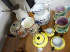 Three piece yellow and black pottery tea service, two Majolica type jugs, a pewter lidded jug etc