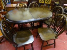 Dark wood oval extending dining table and five wheelback chairs