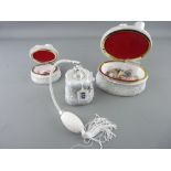 Three piece bow decorated composition dressing table set, two lidded boxes and contents and a