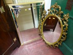 Ornate oval mirror and a square bevelled edge mirror with leaf decoration