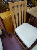 Light wood drop leaf table and four chairs with cream faux leather seats