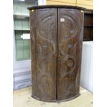 Carved oak bow front hanging wall cupboard