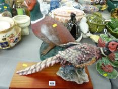 Heavy painted stoneware seated pheasant and a composition model of a pheasant on a wooden base