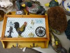 Small decorated wall rack with two hooks and sundry ornaments and a duck foot brush