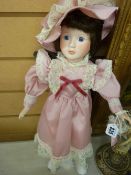Porcelain headed standing doll with pink dress
