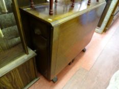 Twin flap gate leg table with interior drawer and storage cupboard