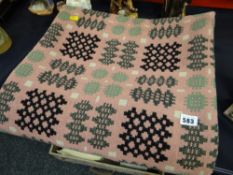 A pink geometric patterned Welsh woollen blanket