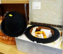 A boxed bowler hat with accessories together with another bowler hat