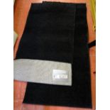 Two retro shaggy plain black rugs