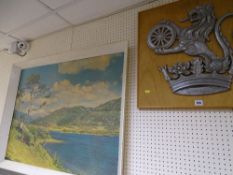 Cast metal lion and crown crest mounted on a board and a large framed print of a lake and mountain