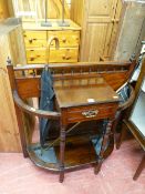 Polished wood hallstand with central drawer and drip trays and a quantity of umbrellas and walking