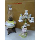 Victorian style oil lamp with glass font and a Continental porcelain figural candelabra showing a