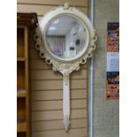 Gilt and painted circular bevelled wall mirror with handle forming the shape of a hand mirror