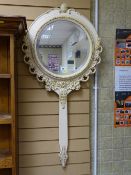 Gilt and painted circular bevelled wall mirror with handle forming the shape of a hand mirror