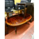 Large oval reproduction low coffee table with twin pedestal supports on brass claw feet and one from