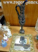 Overlaid glass ewer and a repousse brass bevelled mirror