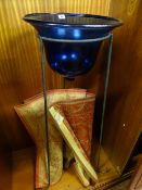 Deep Bristol blue glass basin on a tripod metal high stand and an oblong Laura Ashley rug in