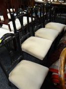 A set of six (4+2) ebonized comb back chairs (5 in cream fabric & 1 in green fabric)