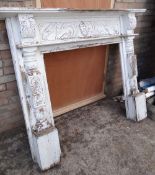 A painted white & decoratively carved wood fire surround (outside)