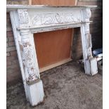 A painted white & decoratively carved wood fire surround (outside)