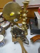 A miniature brass tilt top tripod table, pair of brass candlesticks & three brass trivet stands